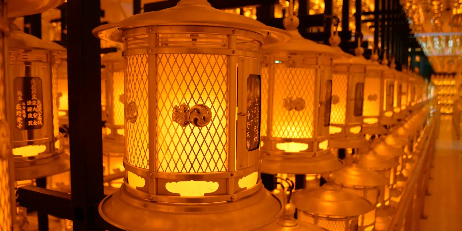 Rows of golden lanterns glowing inside the Torodo, the Hall of Lanterns, at Okunoin on Koyasan
