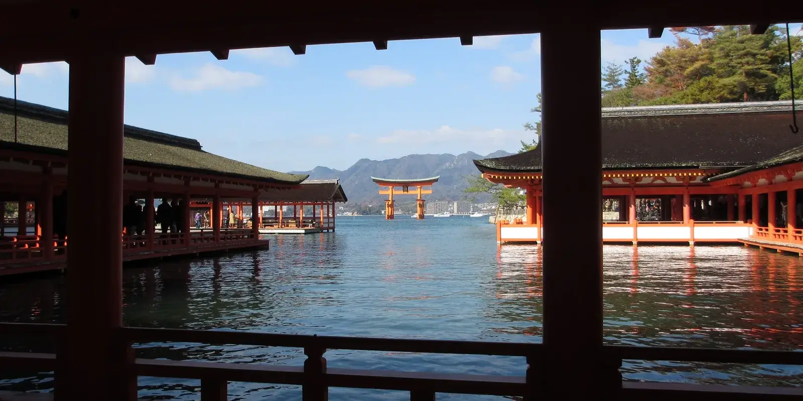 The floating great torii of Itsukushima Shrine at high tide, framed by the vermillion shrine corridors on Miyajima