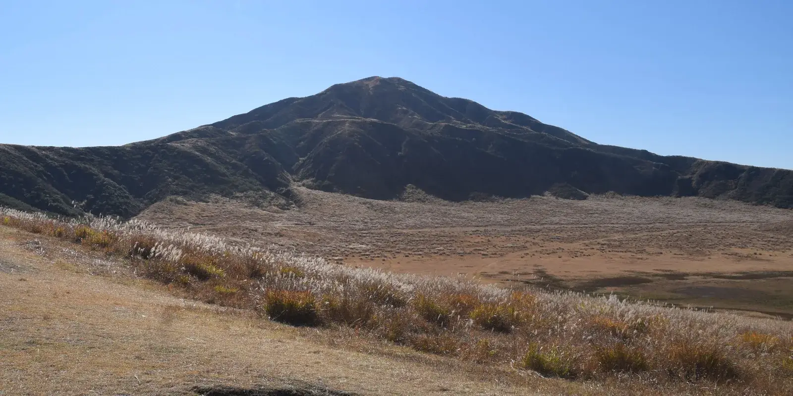 The autumn grassland of Kusasenri below the peak of Eboshidake, inside the Aso caldera