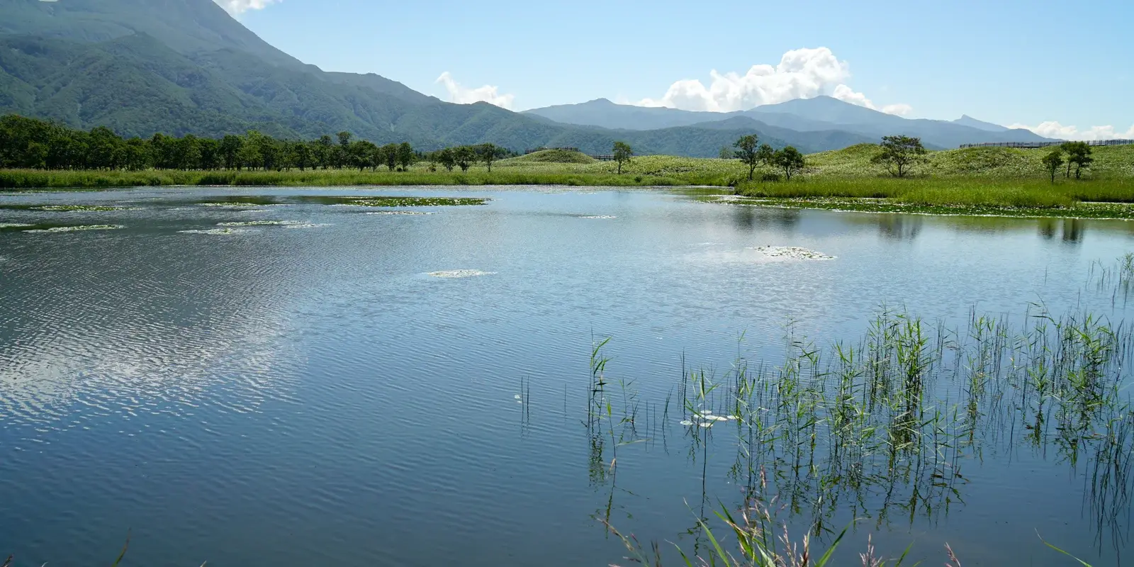 The first of the Shiretoko Five Lakes with the Shiretoko mountain range rising behind it under a clear sky