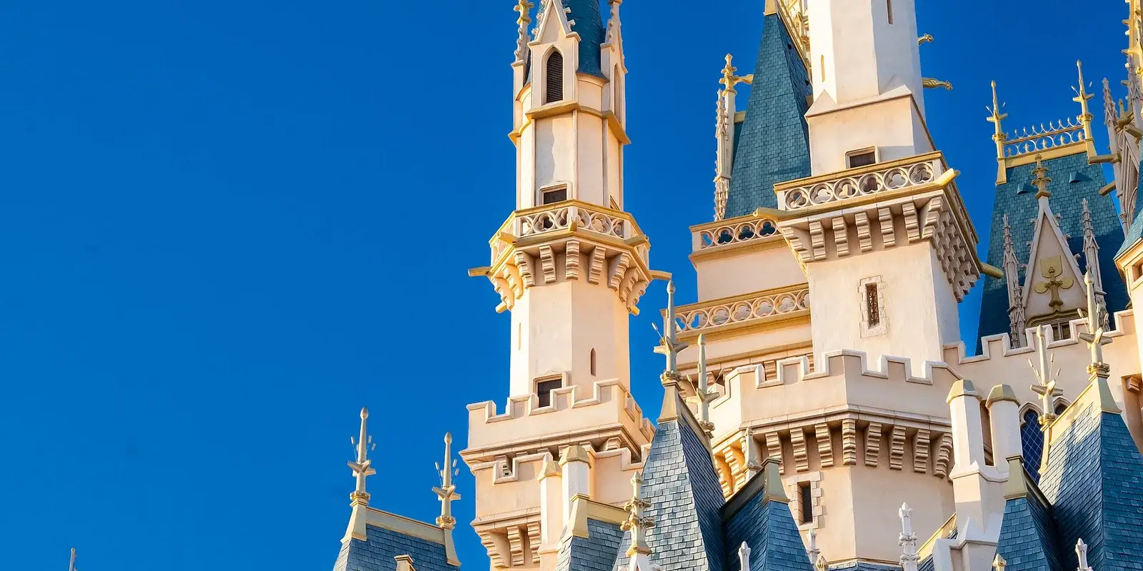 Close-up of Cinderella Castle's Gothic spires and towers against a clear blue sky at Tokyo Disneyland