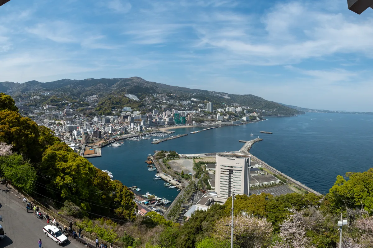 Vista panoramica del mare e dei ciliegi in fiore sulla città e sulla baia di Atami, vista dalla terrazza panoramica del castello