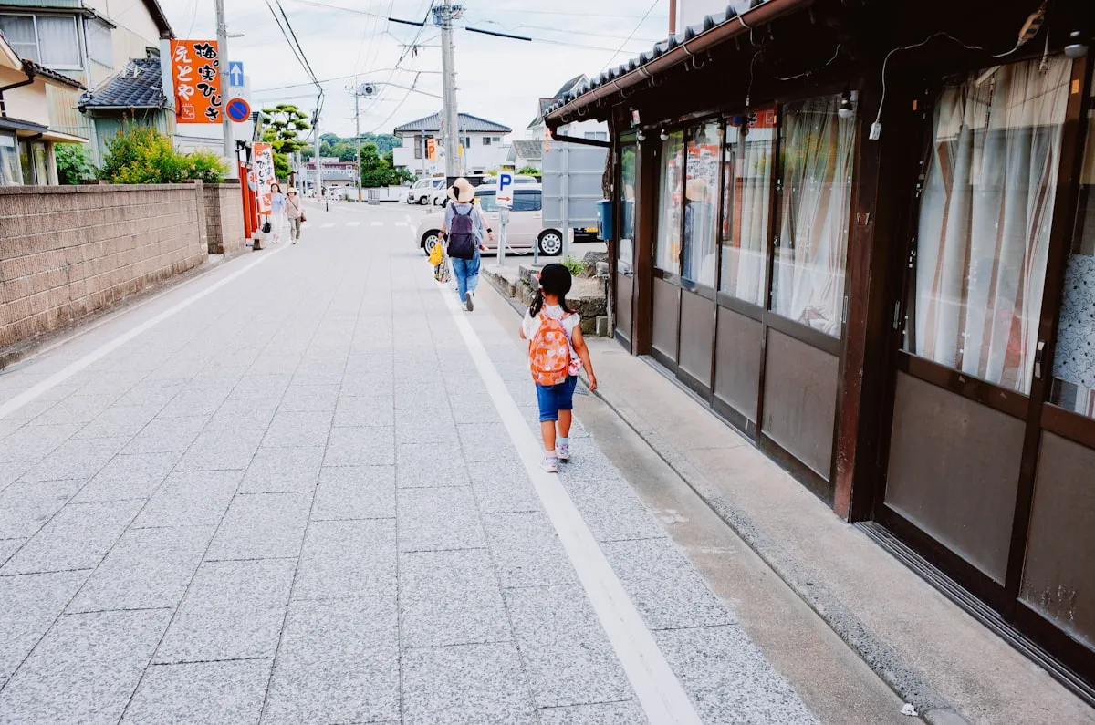 A child walking down a spotless village street in Japan with traditional buildings on either side