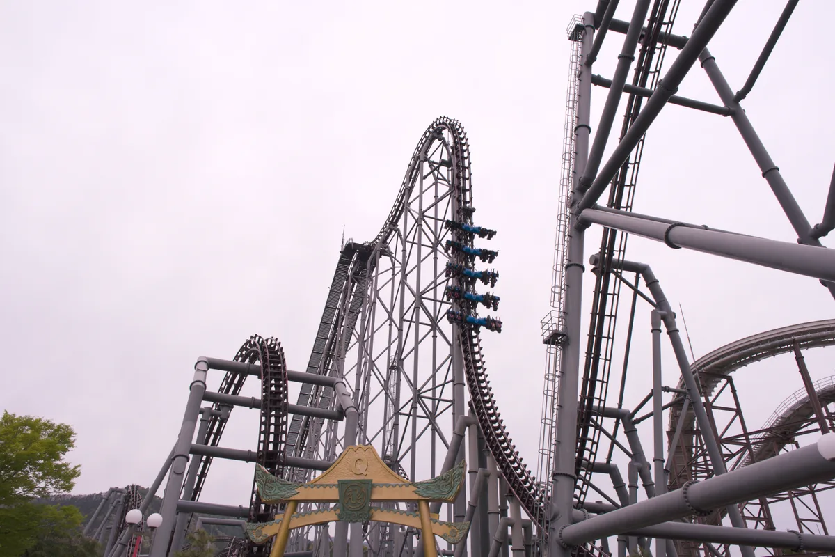 The Eejanaika roller coaster track and its gold-and-green torii gate at Fuji-Q Highland