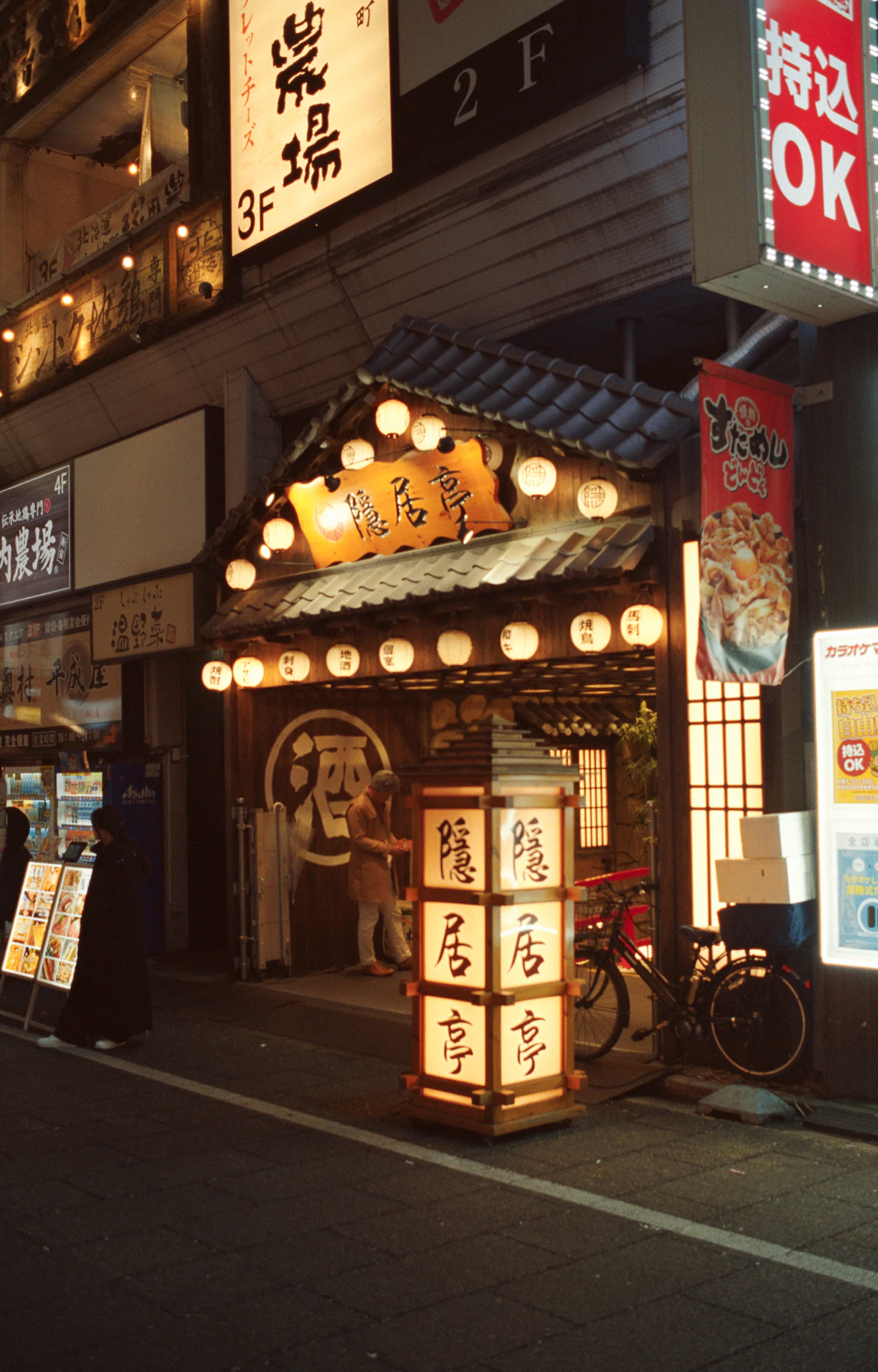 A traditional izakaya entrance in Shinjuku glowing with paper lanterns at night