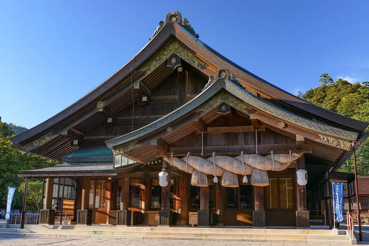 La sala di preghiera di Izumo Taisha sotto un cielo limpido, con la sua corda di paglia intrecciata appesa sotto le profonde gronde di legno