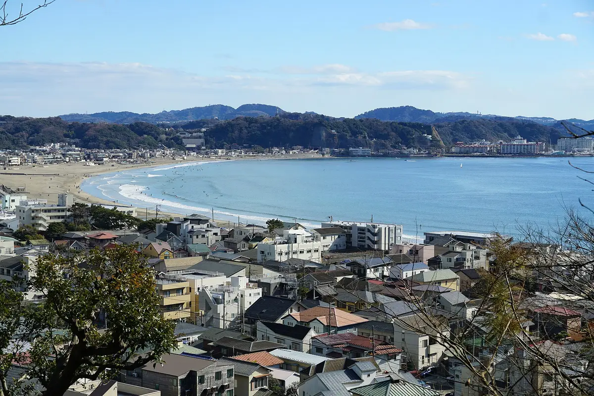 Seen from the hillside above the town: Kamakura's tiled rooftops sloping down to the curving bay and the sand at Yuigahama