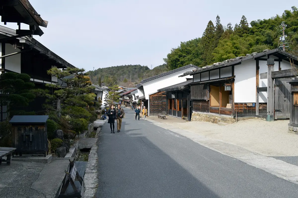 The preserved main street of Tsumago-juku, wooden inns and latticed fronts lining a lane with no cars