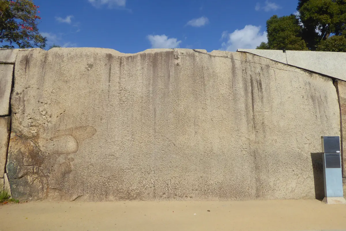La Tako-ishi del castello di Osaka: un'enorme lastra piatta di granito che occupa il muro accanto alla porta Sakura, con un pannello informativo alla sua destra