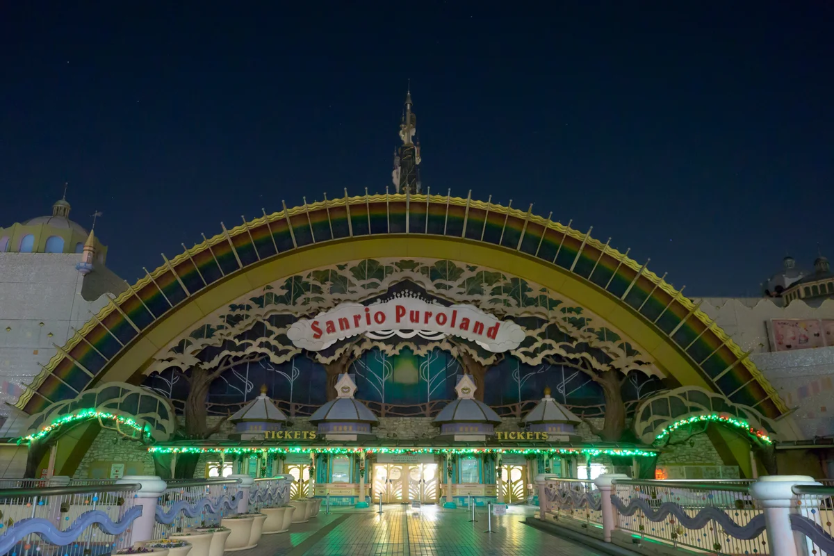 L'ingresso ad arco arcobaleno di Sanrio Puroland illuminato e vuoto dopo l'orario di chiusura