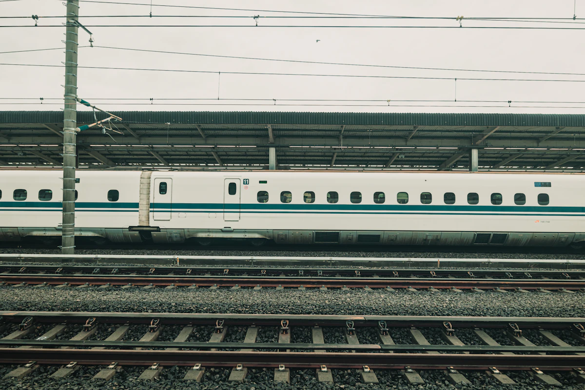 A white Shinkansen bullet train at a Japanese railway platform