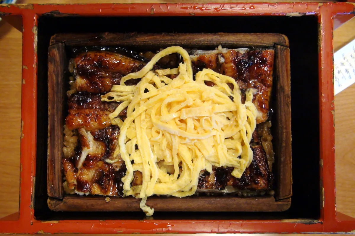 A lacquered steamer box of unagi seiro-mushi, grilled eel and shredded egg over seasoned rice