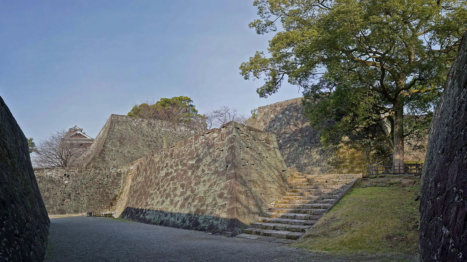Il mastio principale ricostruito del castello di Kumamoto che si erge sopra le muraglie di pietra in restauro