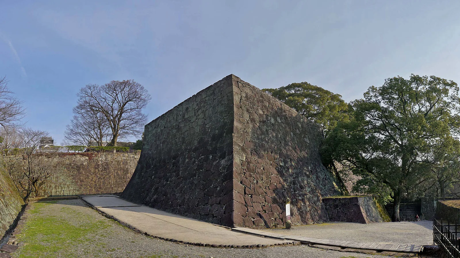 Una muraglia di pietra ripidamente curva del castello di Kumamoto, dolce alla base e quasi verticale in cima, costruita perché non si possa scalare