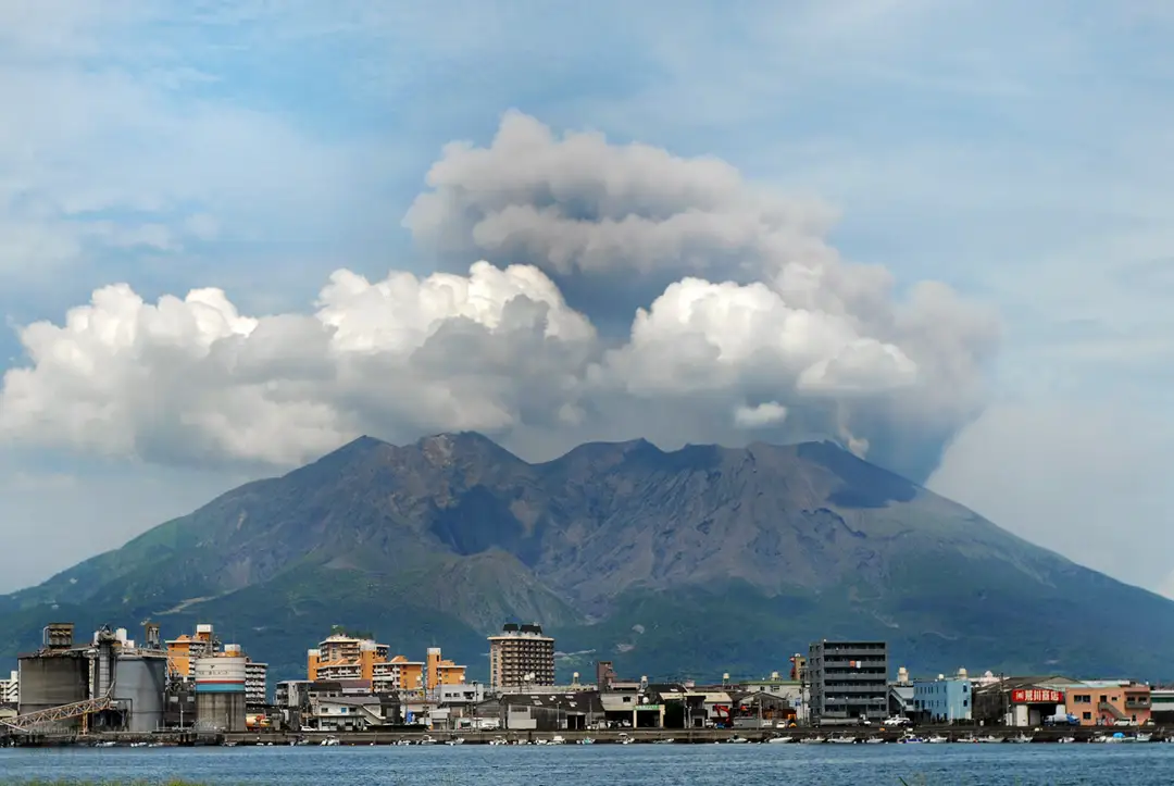 The Sakurajima volcano smoking across the bay above the waterfront of Kagoshima city