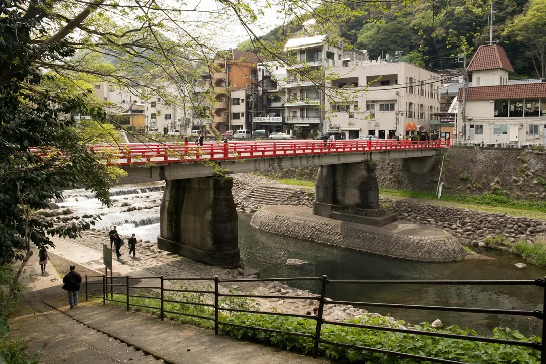 The red Ajisai bridge over the Hayakawa river at Hakone-Yumoto, with the town rising behind it